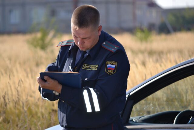 Autoturism care rulează pe o autostradă printre munți, într-o zi senină de vară