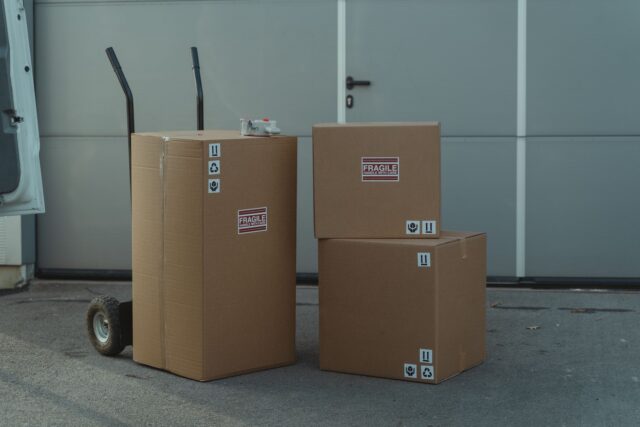 Colete etichetate pregătite pentru expediere internațională, așezate pe o masă de lucru