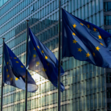Steaguri ale Uniunii Europene arborate în fața unei clădiri administrative moderne